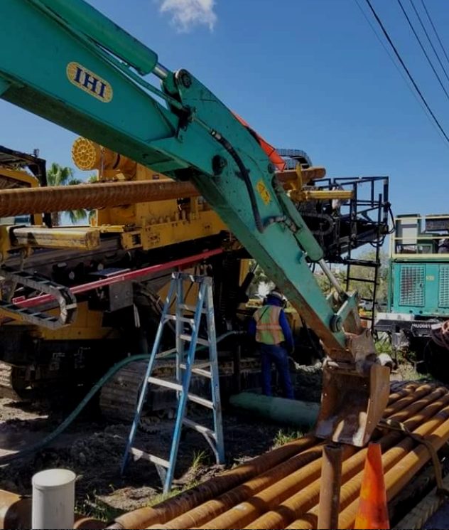 Large directional drill rig with drill pipe racked beside it